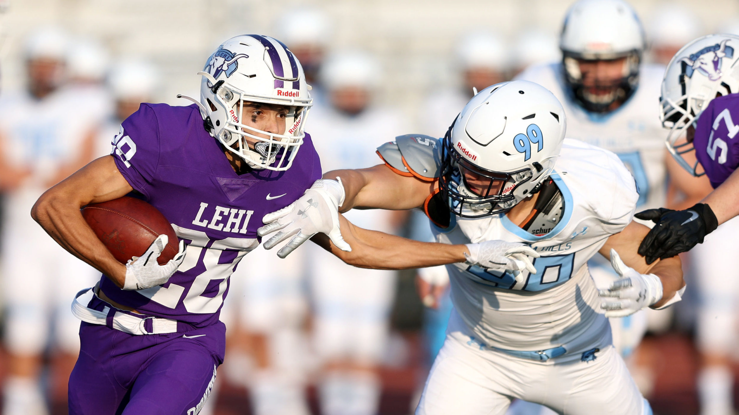 High school football players from two teams are pictured during a game...