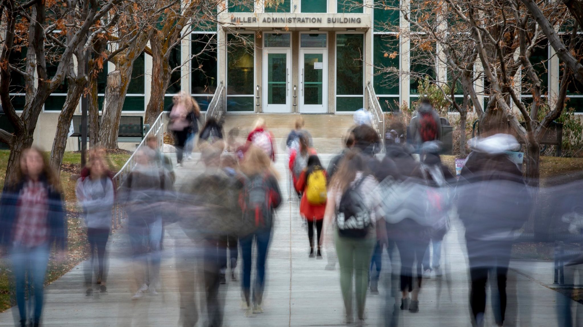 students walking new weber state administration building, higher education spending is in question...