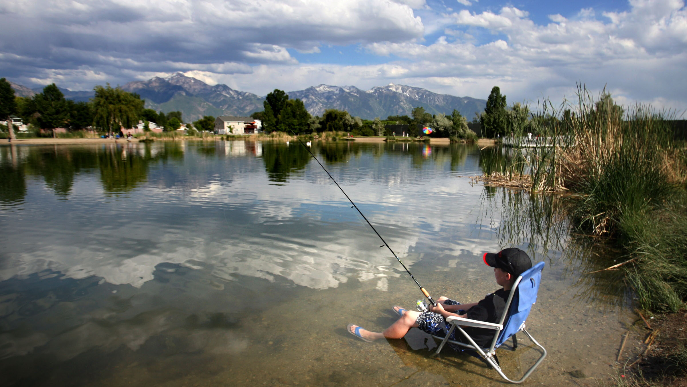 Jack Walpole stays cool by sitting in his chair in the water as he and his family enjoy the day at ...