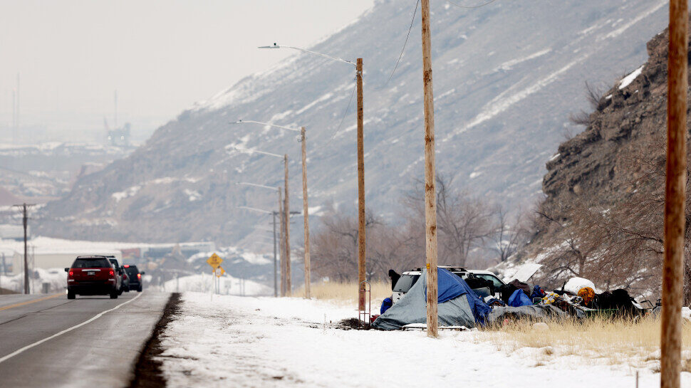 Cars drive past a homeless camp on the side of Victory Road in Salt Lake City on Tuesday, Dec. 20, ...