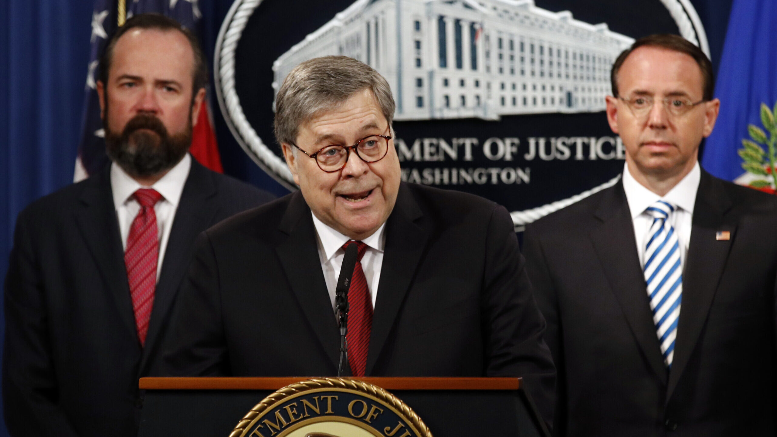 Attorney General William Barr speaks alongside Deputy Attorney General Rod Rosenstein, right, and a...