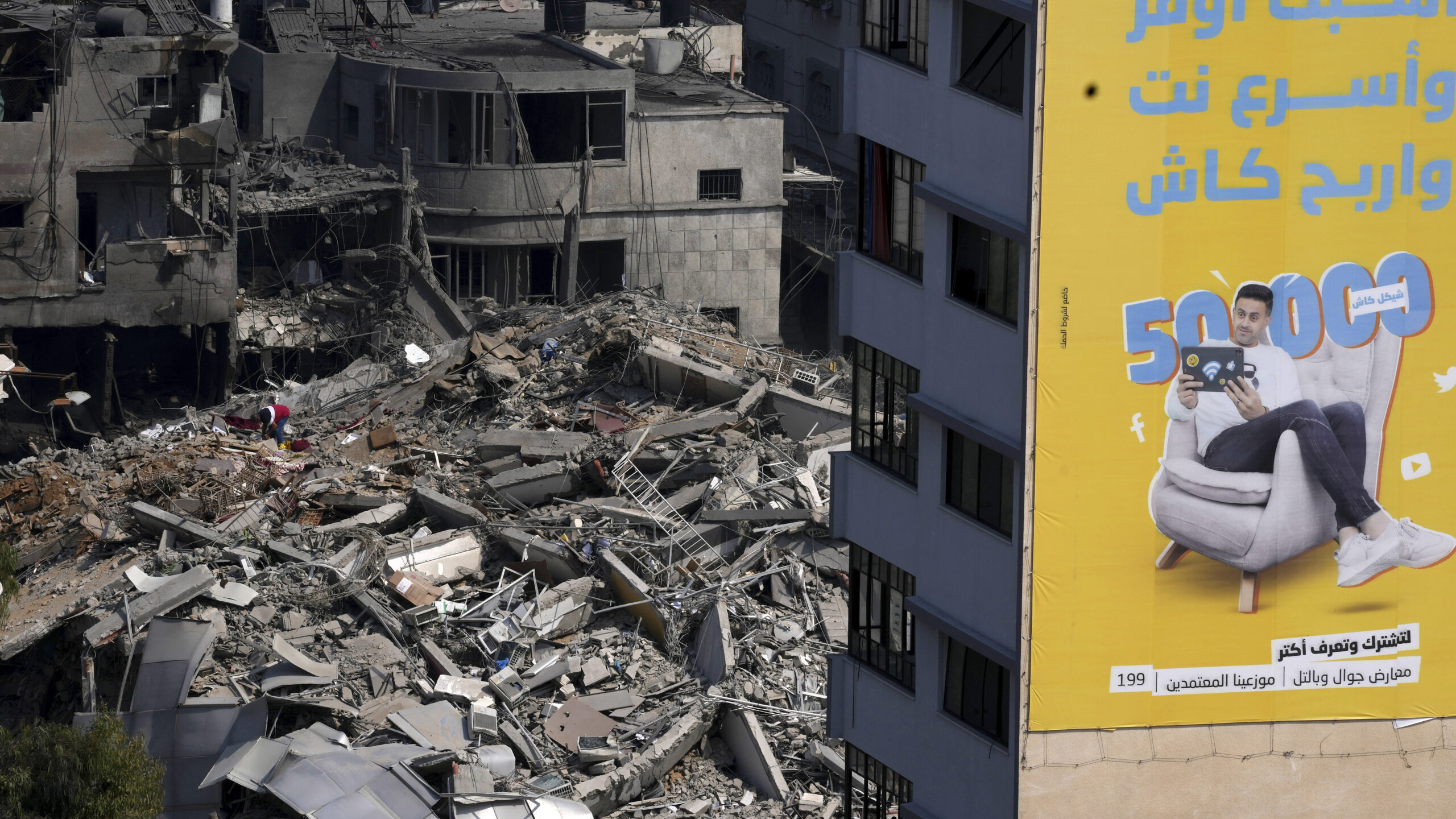 A Palestinian inspects the rubble of a high rise building destroyed by Israeli airstrikes in Gaza C...