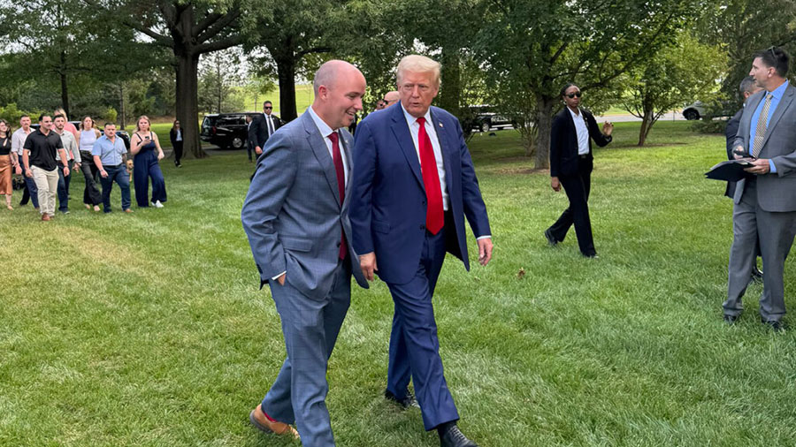 Gov. Spencer Cox walks with former President Donald Trump during a press event at Arlington Nationa...