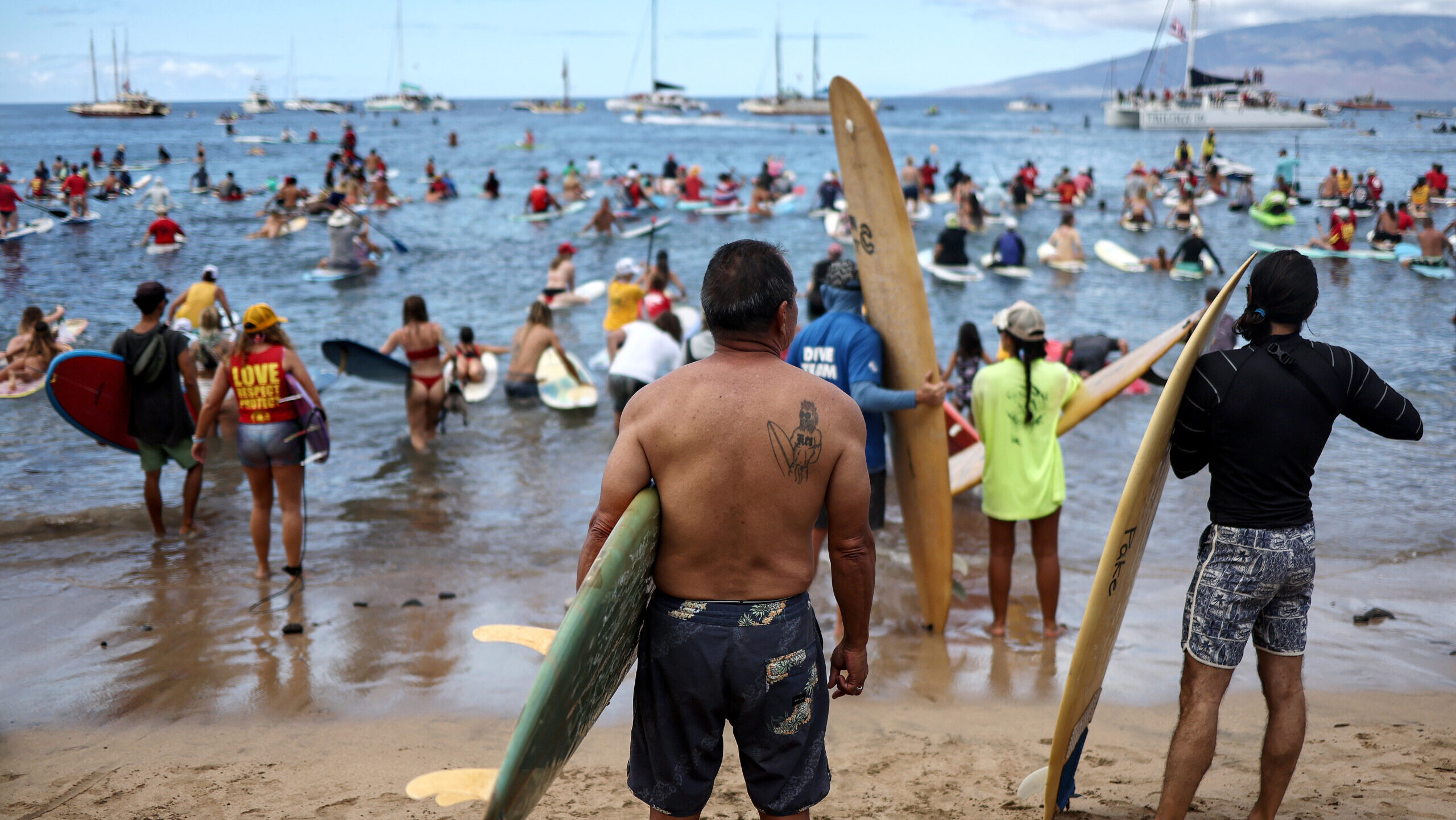 People participate in the Kuhinia Maui Paddle Out remembrance event honoring Lahaina wildfire victi...