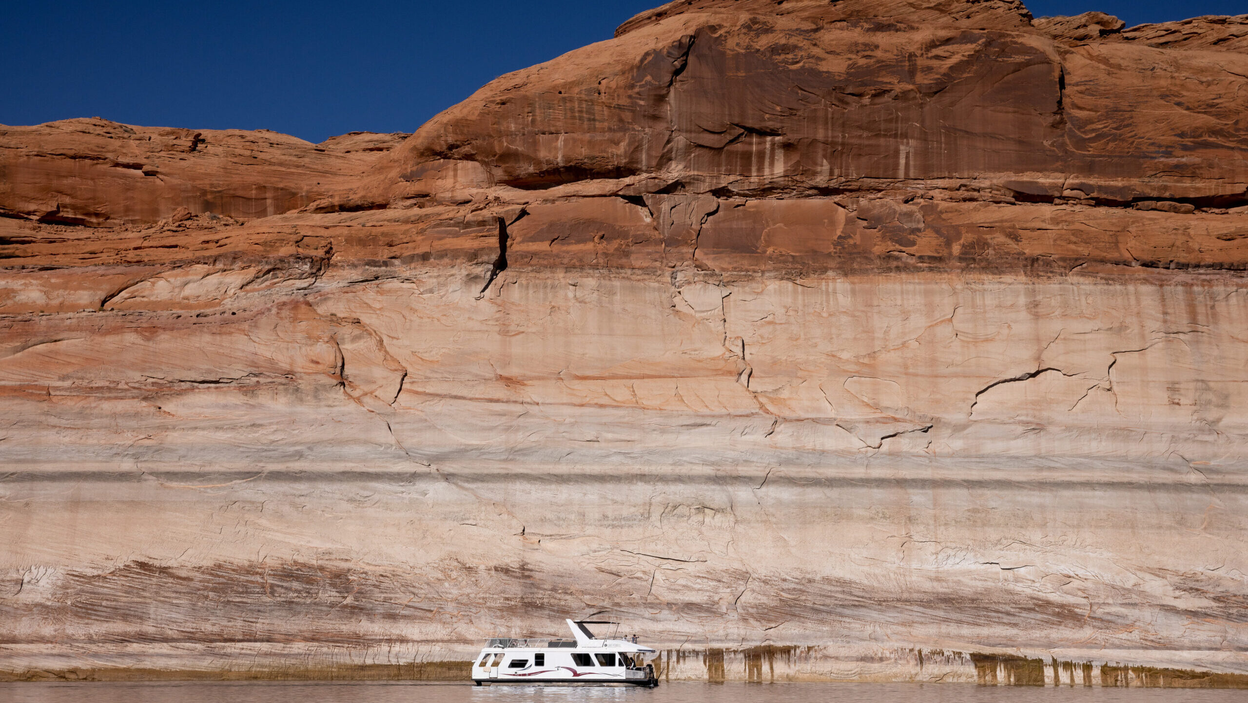 FILE: A houseboat is seen against the backdrop of Lake Powell’s “bathtub ring,” a light-color...