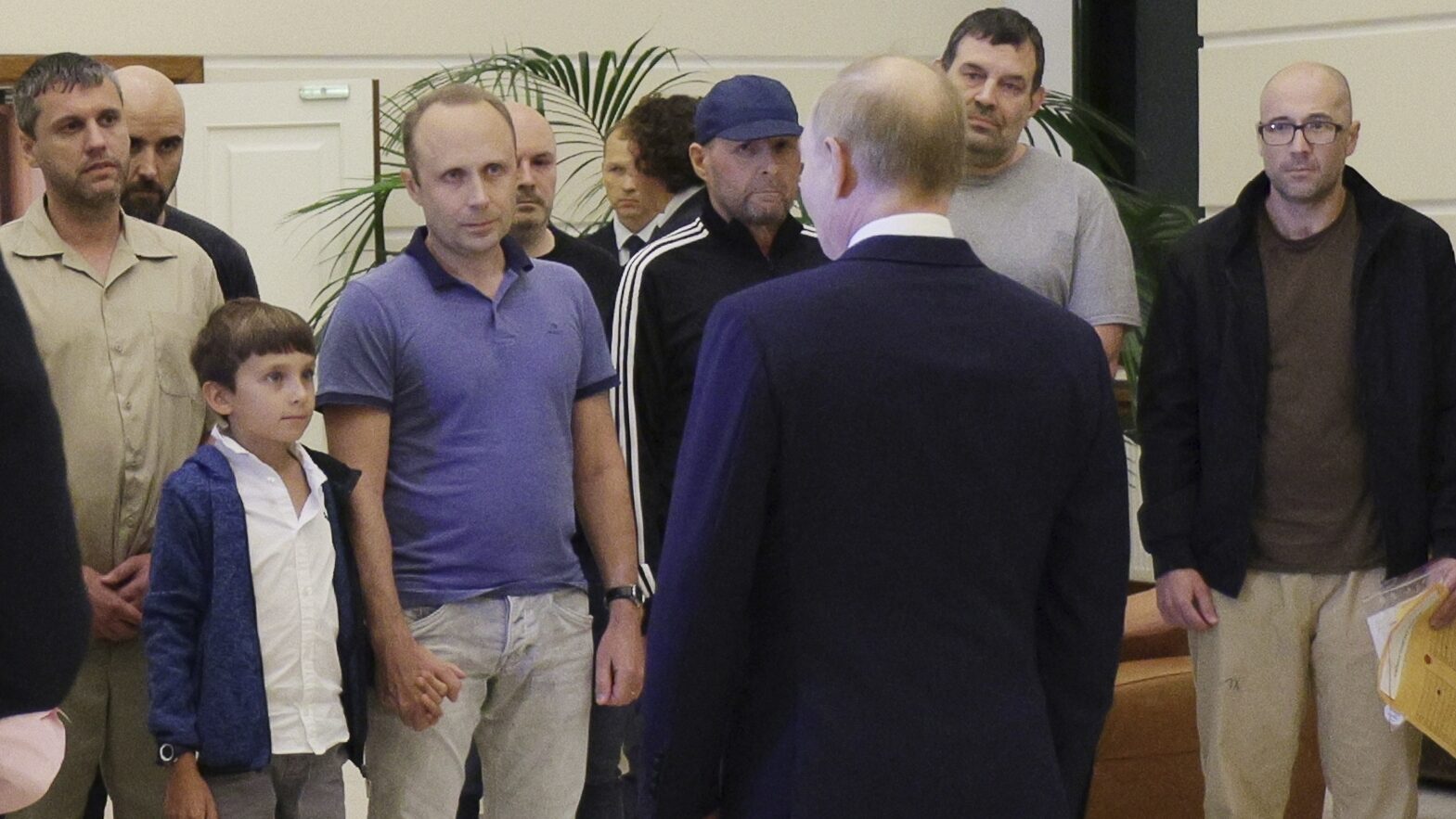 Russian President Vladimir Putin, front, greets released Russian prisoners and relatives at the gov...