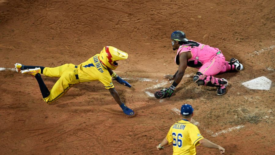 Malachi Mitchell of the Savannah Bananas, left, slides home against Taj Porter of the Party Animals...