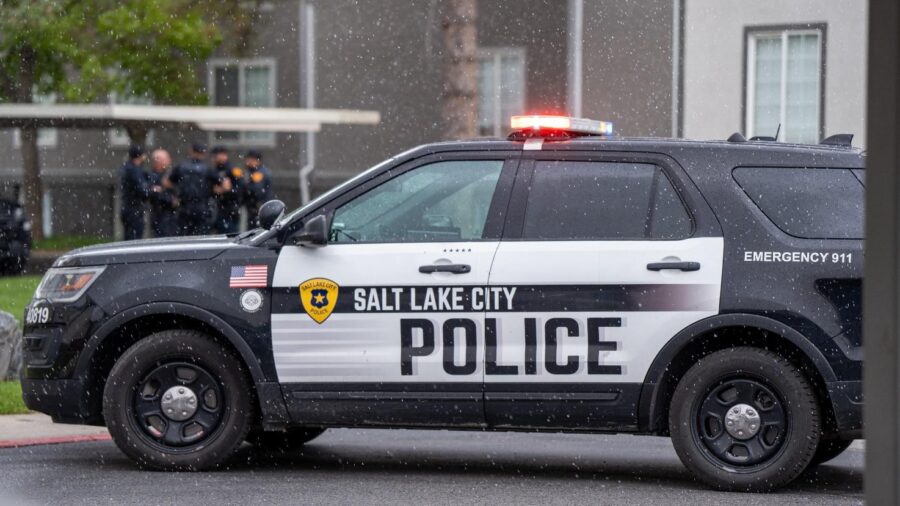 An Salt Lake City Police car with its lights on. A woman has been hospitalized after a house was sh...