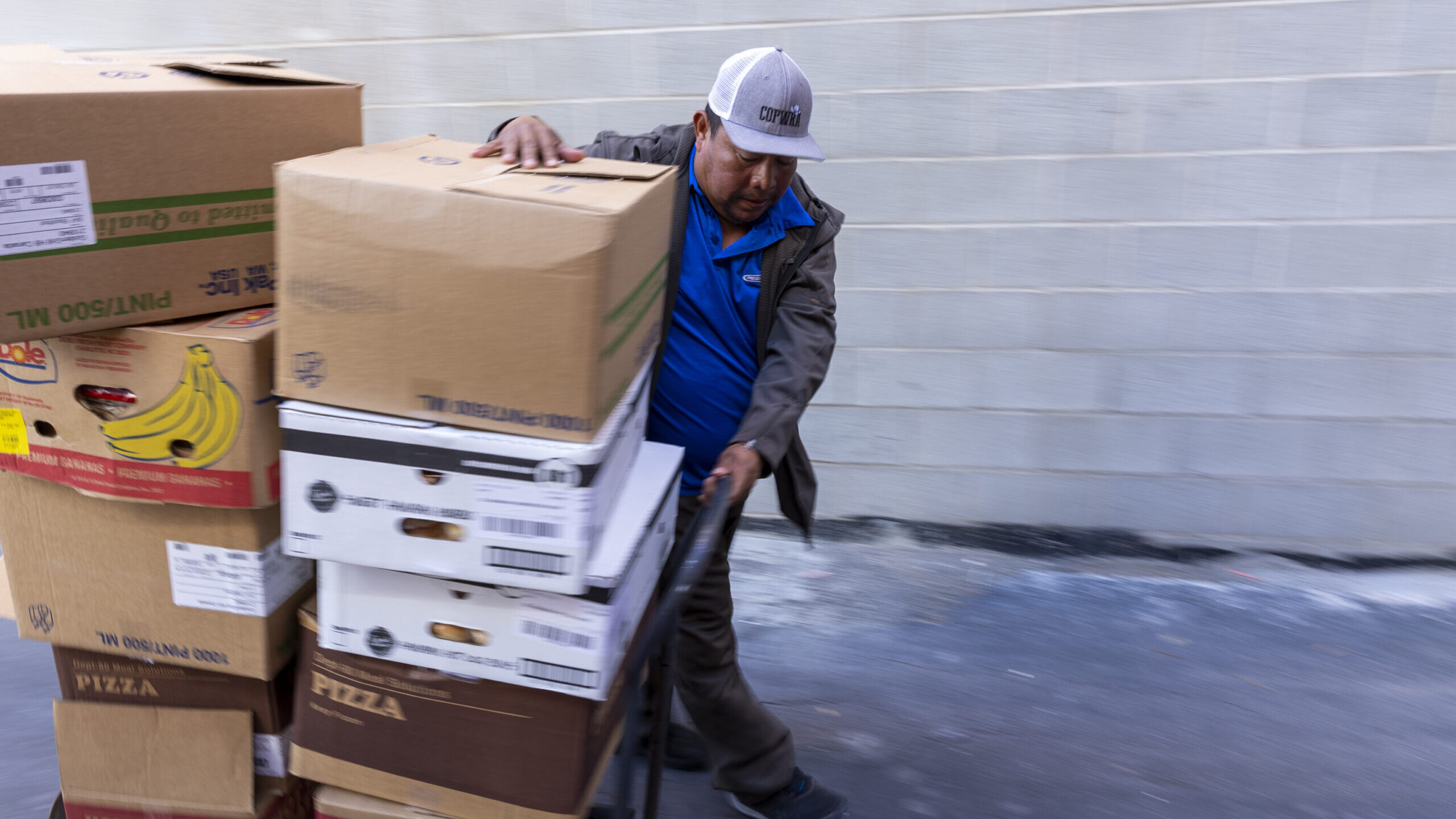 a man moves boxes at the crossroads urban center...