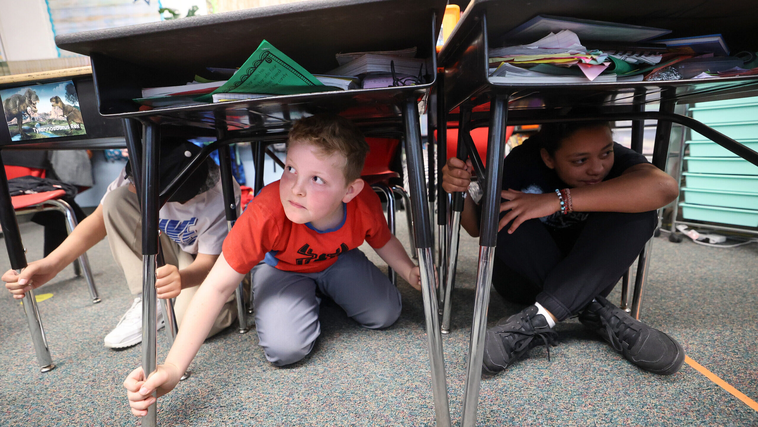 FILE: Fourth graders Jose Gonzalez, Austin Russ and Aaliyah Genao practice taking cover under their...