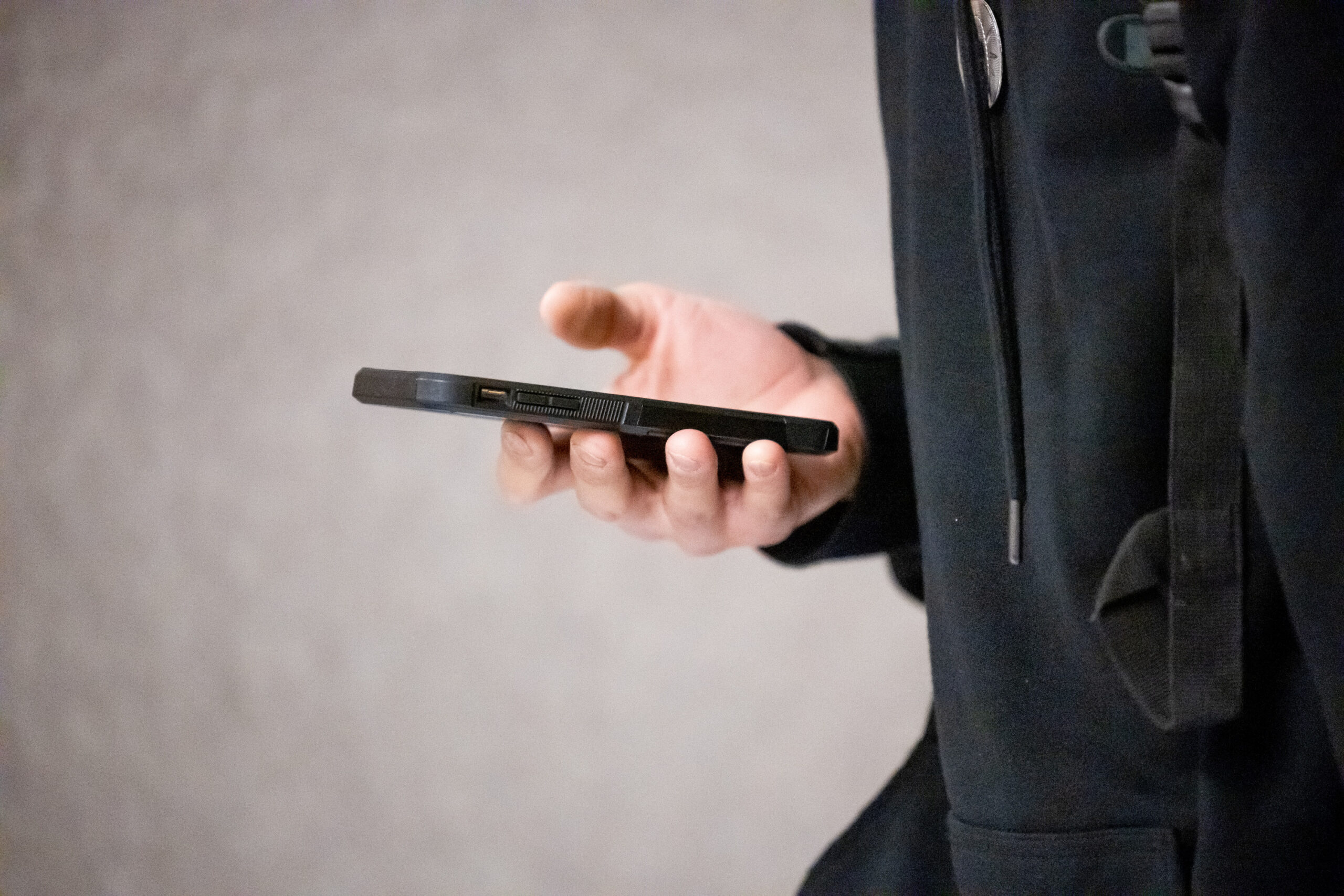 A student uses their phone while walking between classes at Cyprus High School in Magna on Friday, ...