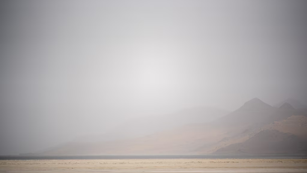 Dust obscures Antelope Island and the exposed bed of the Great Salt Lake...