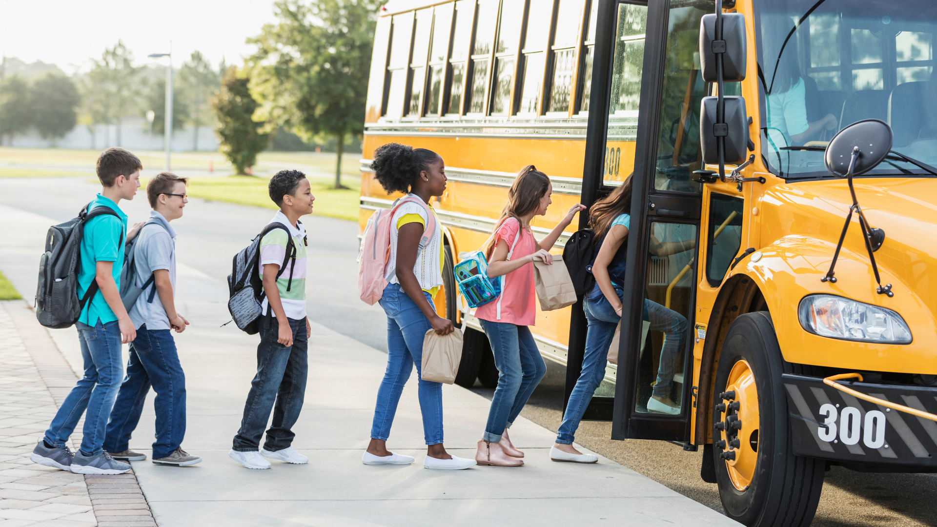 Children board a yellow school bus....